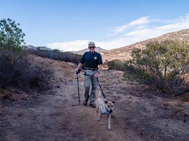 ohn Carroll walks his dog Cooper behind the San Pasqual neighborhood in Escondido on Sept 28, 2022.