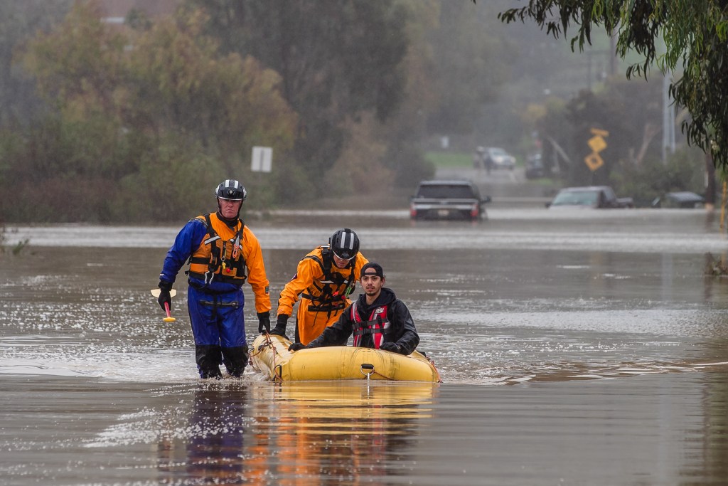 San Diego Lifeguards and Fire Rescue help Victor Nuno to safety in San Ysidro on Jan. 16, 2023.