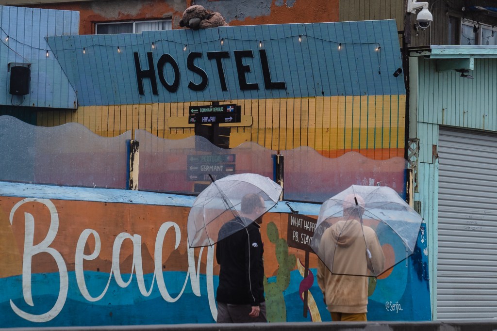 Men walk on the boardwalk in Pacific Beach before tropical storm Hilary makes landfall on Aug. 20, 2023.