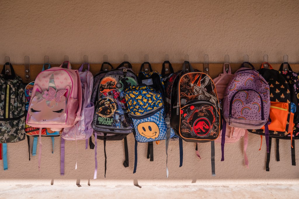 Backpacks hang on the wall outside a classroom at Madison Elementary School in El Cajon on Nov. 9, 2023.